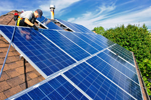 Contractor installing solar panels on a roof